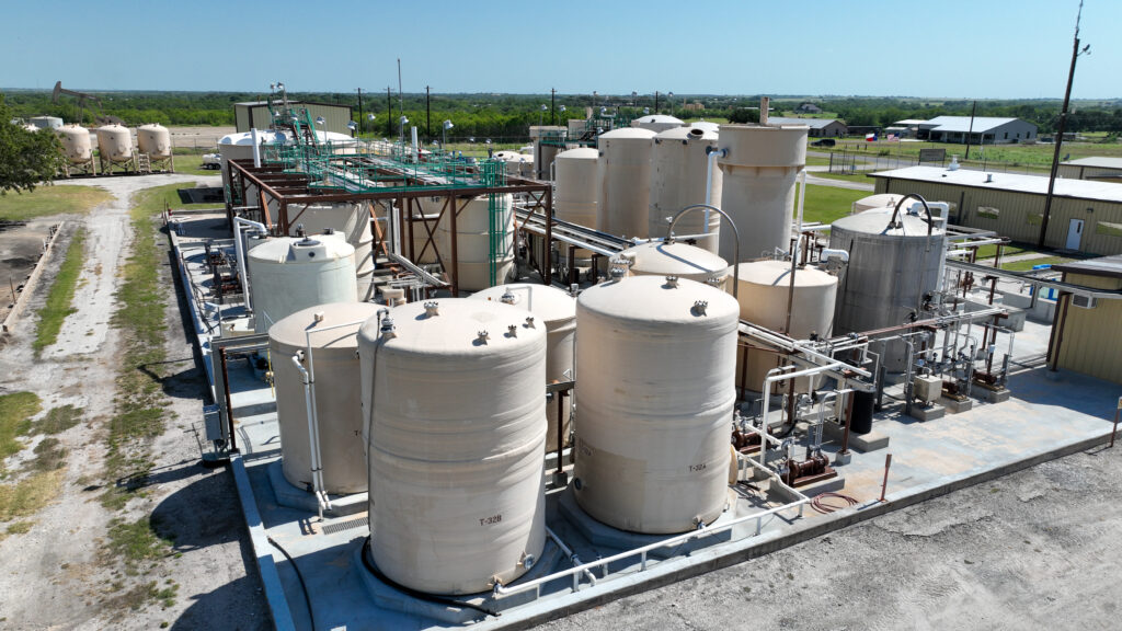 Industrial storage tanks at a plant facility under clear skies.
