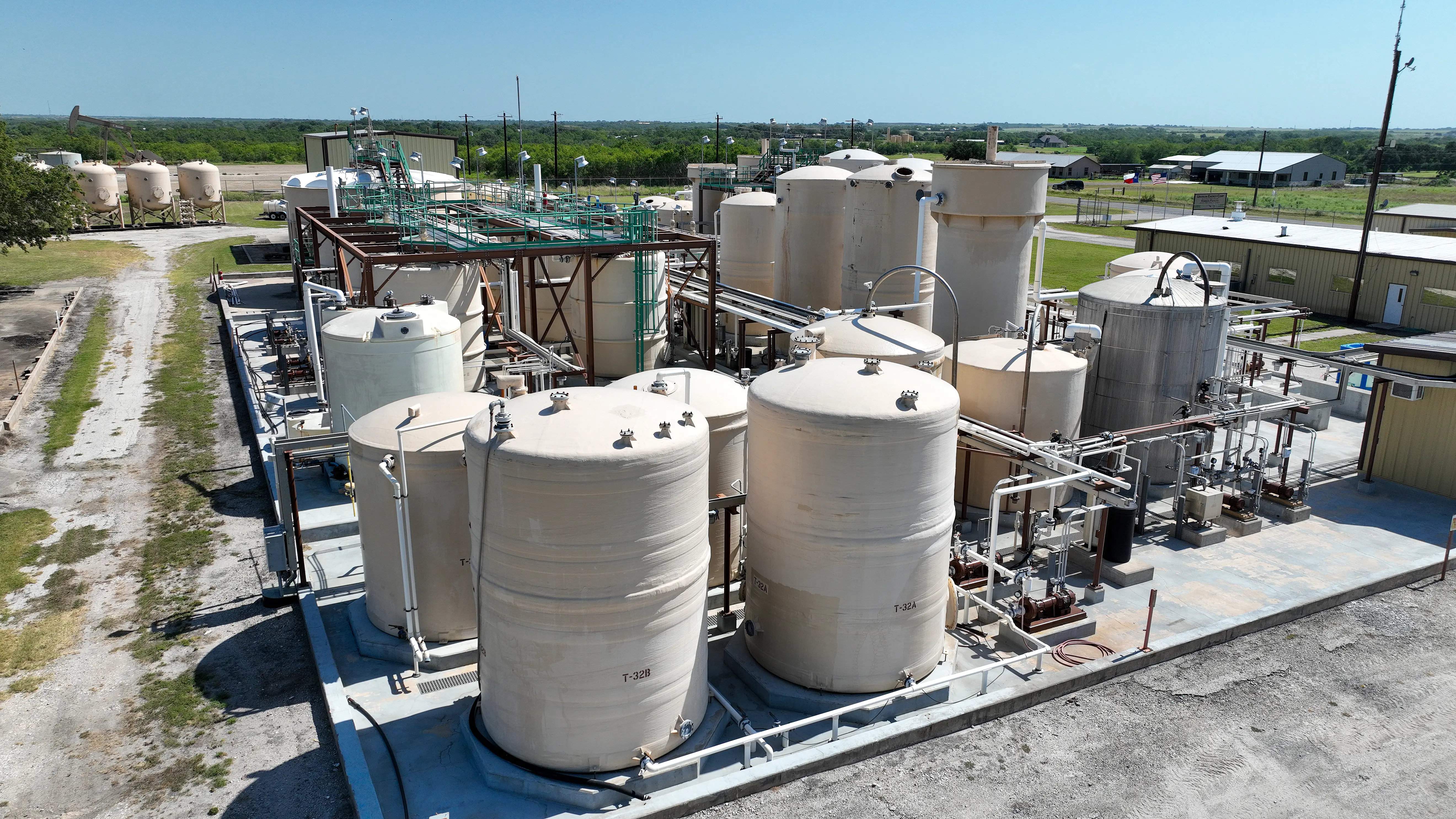 Industrial storage tanks at a plant facility under clear skies.